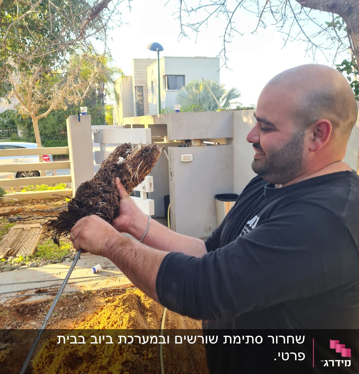 אדם מחזיק שורשים סתומים בצינור ביוב